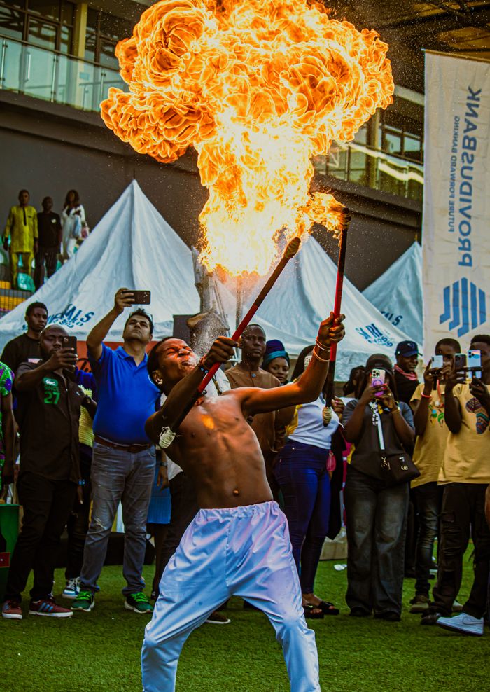 A fire performer thrills a lively crowd at an outdoor event in Lagos, Nigeria.